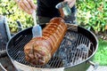 Roasted rolled pork cooking on the barbecue grill Royalty Free Stock Photo