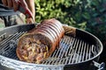 Roasted rolled pork cooking on the barbecue grill Royalty Free Stock Photo