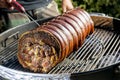 Roasted rolled pork cooking on the barbecue grill Royalty Free Stock Photo