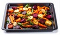 Roasted Root Vegetables on Dark Baking Tray with Green Herbs Overhead View Royalty Free Stock Photo