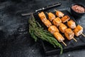 Roasted salmon kebab skewers on marble board. Black background. Top View. Copy space Royalty Free Stock Photo