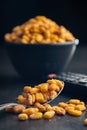 Roasted salted corn snack in spoon on black table Royalty Free Stock Photo