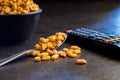 Roasted salted corn snack in spoon on black table Royalty Free Stock Photo