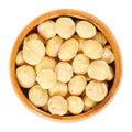 Roasted macadamia nuts in wooden bowl over white Royalty Free Stock Photo