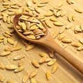 Roasted salted organic dry melon seeds, in wooden spoon on bamboo cutting board Royalty Free Stock Photo