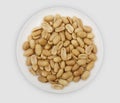 Roasted salted peanuts on a white plate Royalty Free Stock Photo