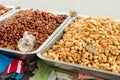 Roasted, salted peeled and unpeeled, crude peanuts on metal trays on the street market in the Philippines