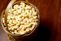 Roasted salted raw cashew nuts in wooden bowl on rustic table, healthy vegetarian snack, Anacardium occidentale, Cashews on white