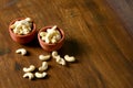 Roasted salted raw cashew nuts in wooden bowl on rustic table, healthy vegetarian snack, Anacardium occidentale, Cashews on white Royalty Free Stock Photo