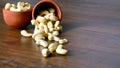 Roasted salted raw cashew nuts in wooden bowl on rustic table, healthy vegetarian snack, Anacardium occidentale, Cashews on white Royalty Free Stock Photo