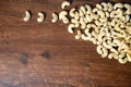 Roasted salted raw cashew nuts in wooden bowl on rustic table, healthy vegetarian snack, Anacardium occidentale, Cashews on white