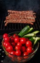 Roasted sausages cooking on flaming grill barbecue and vegetables.