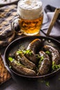 Roasted sausages in pan with bread herbs and draft beer. Royalty Free Stock Photo