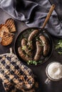 Roasted sausages in pan with bread herbs and draft beer. Royalty Free Stock Photo