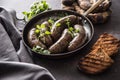 Roasted sausages in pan with bread and herbs. Royalty Free Stock Photo