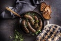 Roasted sausages in pan with bread and herbs. Royalty Free Stock Photo