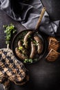 Roasted sausages in pan with bread and herbs. Royalty Free Stock Photo