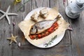 Roasted sea bream served with vegetables, on a plate, top view. Whole, baked fish on a parchment paper. Royalty Free Stock Photo