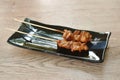 roasted slice chicken dressing Japanese teriyaki sauce stabbing wooden stick on plate