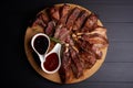 Roasted sliced barbecue pork ribs with aromatic herbs and two kinds of souce, top view Royalty Free Stock Photo