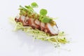 Roasted sliced octopus with sprout and green cabbage on white ba