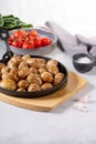 Roasted small whole potatoes in a cast iron skillet on concrete background. Vegetarian or vegan food concept