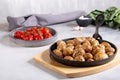 Roasted small whole potatoes in a cast iron skillet on concrete background. Vegetarian or vegan food concept