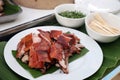 Roasted suckling pig, crispy skin, cut into pieces Looks delicious on a white plate, beneath the pork with banana leaves. Royalty Free Stock Photo