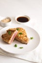 Roasted tuna steak in sesame seeds with soy sauce on a plate on a white table, copy space, vertical Royalty Free Stock Photo