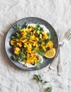 Roasted turmeric cauliflower with greek yogurt dressing. Delicious healthy food on a grey background