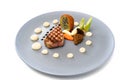 Roasted veal, morels, vegetables and a fried potato stuffed with onion seeds on a blue plate, festive garnished gourmet dish on a