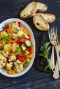 Roasted vegetables - zucchini, cauliflower, potatoes, carrots, onions, peppers, on an oval dish