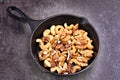 Roasted walnuts and cashews on a cast iron pan. Royalty Free Stock Photo