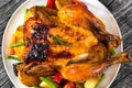 Roasted whole chicken, potatoes, baby carrots, eggplants, green Royalty Free Stock Photo