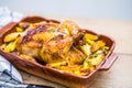 Roasted whole chicken with potatoes in baking dish. Tasty food at home on the kitchen counter Royalty Free Stock Photo