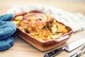 Roasted whole chicken with potatoes in baking dish. Tasty food at home on the kitchen counter Royalty Free Stock Photo