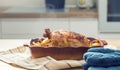 Roasted whole chicken with potatoes in baking dish. Tasty food at home on the kitchen counter Royalty Free Stock Photo