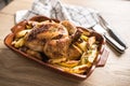 Roasted whole chicken with potatoes in baking dish. Tasty food a Royalty Free Stock Photo