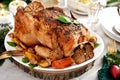 Roasted whole chicken with vegetables and garlic on Christmas table Royalty Free Stock Photo