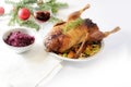 Roasted whole duck with vegetables, red cabbage and wine on a white table with Christmas decoration, copy space Royalty Free Stock Photo