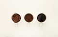 Roasted whole and ground coffee beans in cups, top view, white i Royalty Free Stock Photo