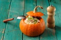 Roasted whole pumpkin with rice and meat with pepper mill Royalty Free Stock Photo