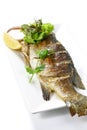 Roasted Whole Seabass Fish Pra-Kra-Pong with Red Chili Garlic Seafood Sauce and a piece of lemon on white porcelain plate, Royalty Free Stock Photo