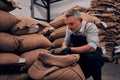 Roastery owner checking roasted coffee beans in sack, selective focus Royalty Free Stock Photo