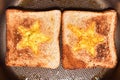 Roasting bread toasts with a star-shaped middle and omelette filled with egg to create a sandwich. Bread is fried for sandwiches