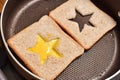 Roasting bread toasts with a star-shaped middle and omelette filled with egg to create a sandwich. Bread is fried for sandwiches