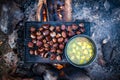 Roasting chestnuts and boiling potato stew on open fire with lots of smoke delicious camper meal van life concept Royalty Free Stock Photo