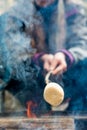 Roasting large marshmallow on a stick over the campfire. Camping family fun