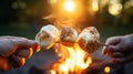 Roasting marshmallows on stick close up with hands in the warmth of an evening campfire