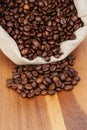 Roated coffee beans spill out of the bag Royalty Free Stock Photo